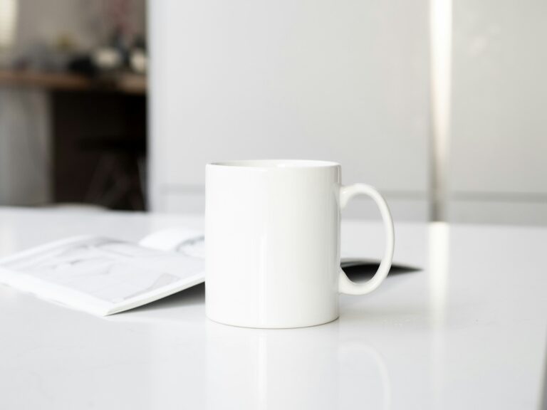 a white coffee cup sitting on top of a white table